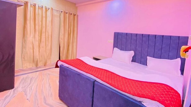 Een moderne slaapkamer met een bed, gordijnen en een plafondlamp.