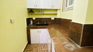 Een smalle keuken met witte kasten, een visgraatvloer en een bruin aanrecht.