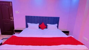 Een slaapkamer met een bed, een plafondventilator en een deur.