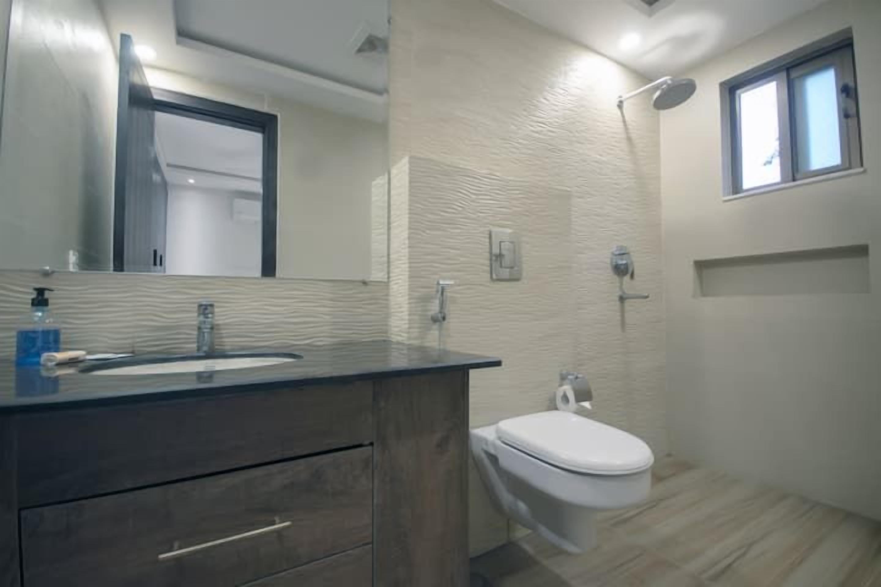 A bathroom with a sink, toilet, and shower.