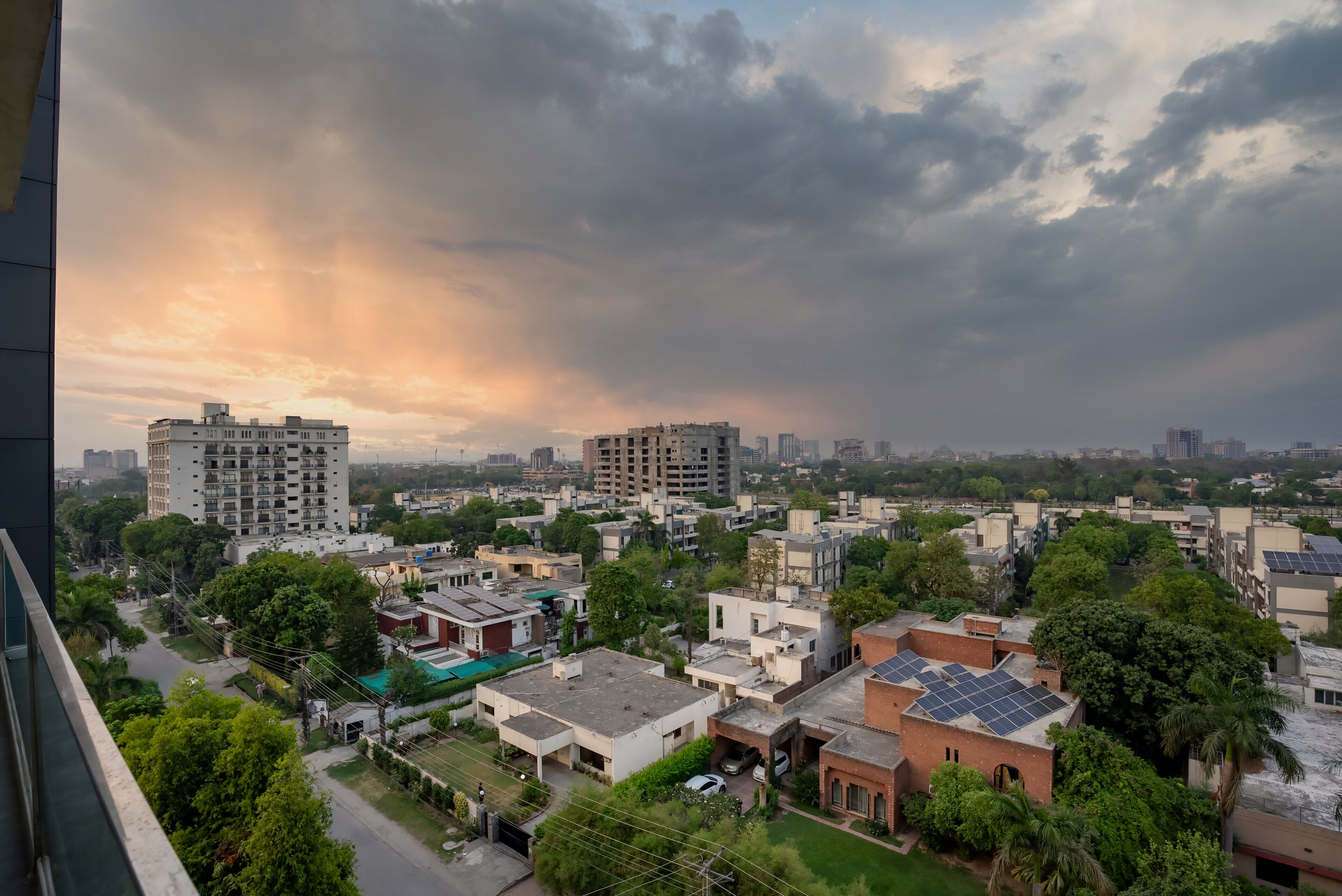 A residential area with various buildings, including multi-story apartment complexes and single-family homes, under a cloudy sky.