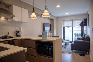 Enjoy a city view from the large window in this apartment, which features a sleek kitchen, comfortable seating area, and pendant lighting.