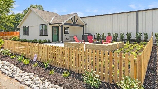 A residential property with a two-story house, a fenced backyard, and a patio area with outdoor seating. - Pilot's Pad Studio on 75 Acres + Fishing Pond (Pleasant Hill)
