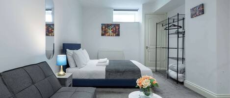 Escritorio, tabla de planchar con plancha, wifi y ropa de cama