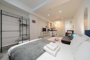 A modern hotel room with a large bed, a built-in wardrobe, a kitchenette, and a separate bathroom. - Chic Shoreditch Studio,Fast Wi-Fi & Top Location (London)