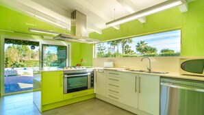 A kitchen with a large island, stainless steel appliances, and a view of the outdoors. - Villa Pancho - Large garden (Alcúdia)