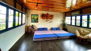 Een kamer met een bed, een stoel, een schilderij en een raam.
