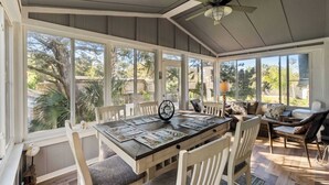 A sunroom with a dining table, chairs, and a sofa. - Lighthouse Loft l Marshfront l Walk to Downtown (St. Augustine)