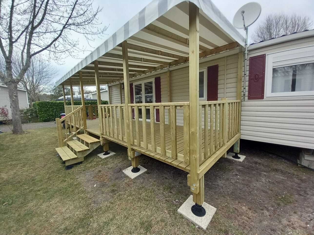 A wooden deck with a staircase leading to a covered porch.