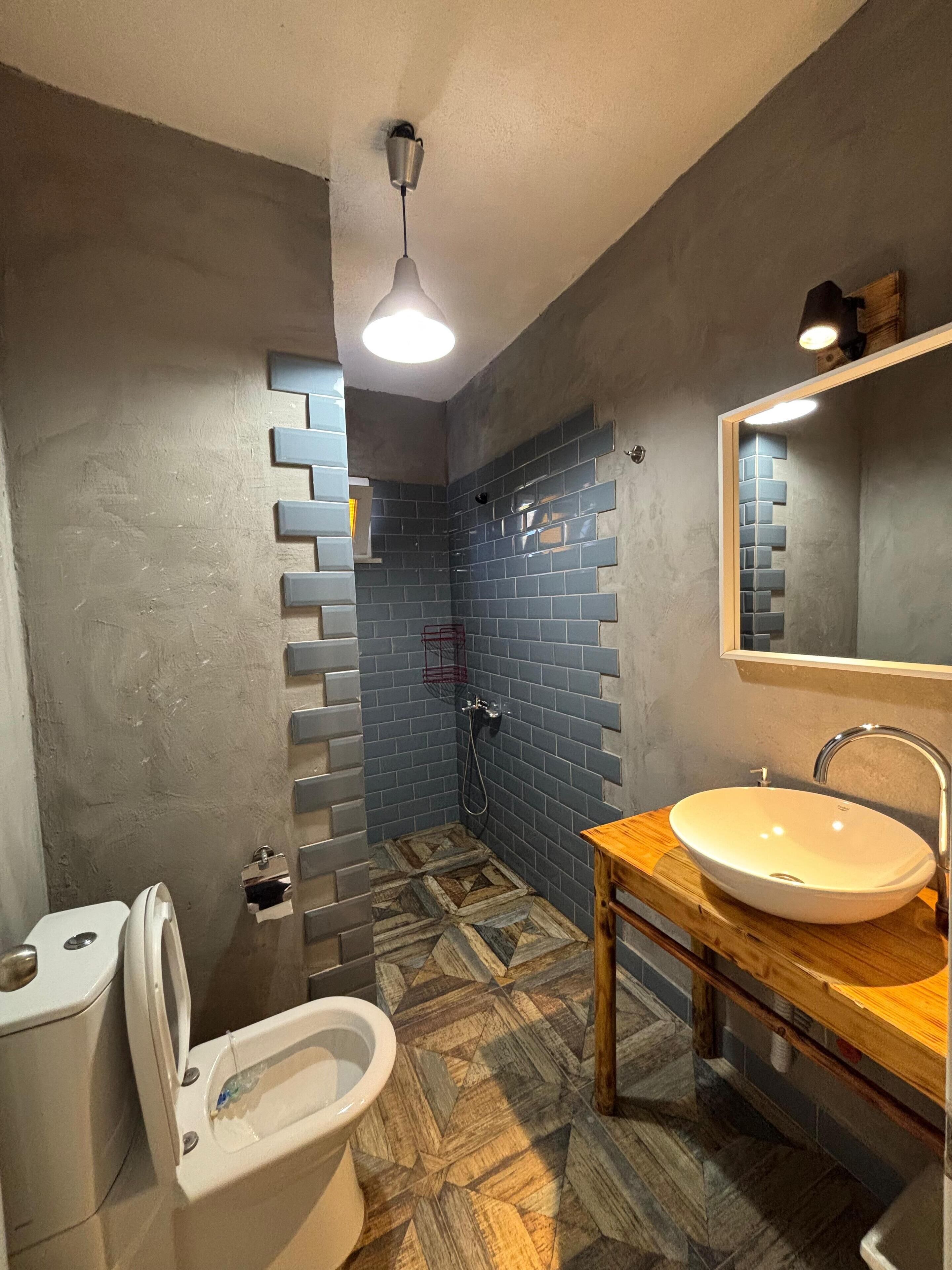 A bathroom with a shower, toilet, and sink.