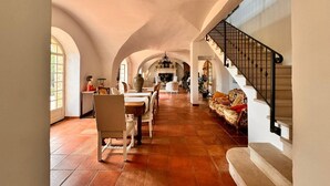 Un interior espacioso con comedor, escalera y chimenea.