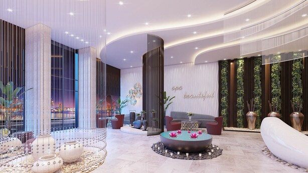 A modern lobby with a reception desk, seating area, and decorative elements like vases and a water feature.