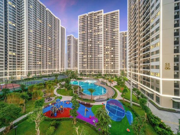 A residential complex with high-rise buildings, a central swimming pool, and a playground area. - Radiant Vinhomes Smart City - Apartment (Hanoi)