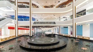 A multi-level atrium with a central water feature and seating areas.