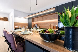 Una cocina moderna con encimera de madera, un tazón grande de fruta y un jarrón de tulipanes.