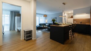 A modern apartment with a kitchen, dining area, and living room. - Beach shell vacation apartment at Villa Beatrice - your retreat in Binz (Binz)