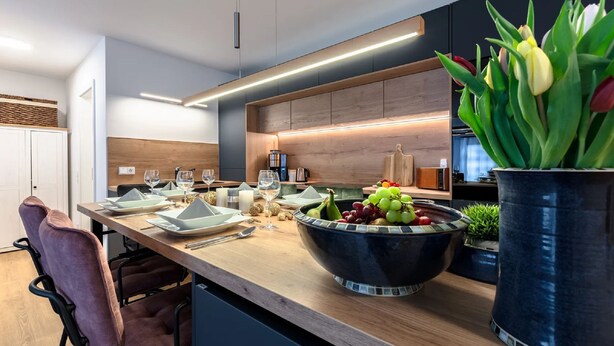 A modern kitchen with a wooden countertop, a large bowl of fruit, and a potted plant. - Beach shell vacation apartment at Villa Beatrice - your retreat in Binz (Binz)