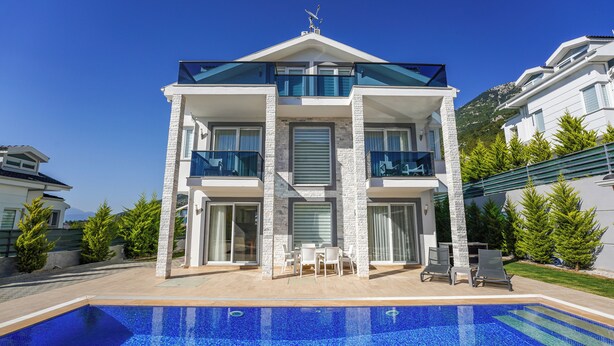 A modern two-story building with a swimming pool in front.