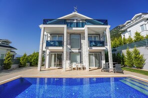 Un edificio moderno de dos pisos con una piscina frente a él.