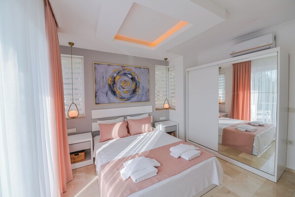 Un dormitorio moderno con una cama grande, mesitas de noche, un espejo y una lámpara de techo.