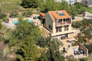 A modern two-story house with a balcony, a swimming pool, and a patio area. - Casa Malinas (Stanici)