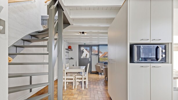 A modern kitchen with white cabinets, a built-in microwave, and a herringbone-patterned floor. - 3 bedroom accommodation in Nieuwpoort (Nieuwpoort)