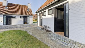 A modern house with a white exterior, a tiled roof, and a gravel driveway. - 3 bedroom accommodation in Nieuwpoort (Nieuwpoort)