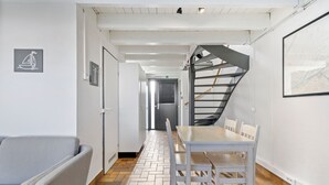 A modern interior with a dining area, a staircase, and a sofa. - 3 bedroom accommodation in Nieuwpoort (Nieuwpoort)