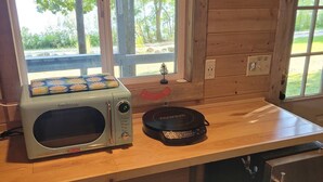 Una cucina accessoriata con forno a microonde, macchina del caffè e lavandino.