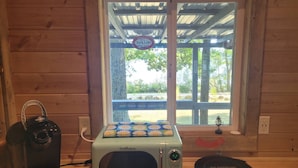 Un angolo cottura con macchina del caffè, forno a microonde e tostapane.