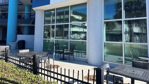 Un edificio moderno con grandes ventanales, mesas al aire libre y un letrero de Starbucks.