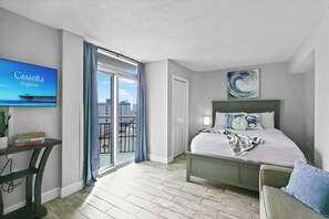 Ein modernes Schlafzimmer mit Bett, Schreibtisch und Fernseher, der 'Casanita Properties' anzeigt.