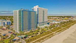 Un hotel moderno de muchas plantas, con aparcamiento y ubicación frente a la playa.