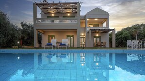 A modern two-story house with a swimming pool in front, featuring outdoor seating and a pergola. - Villa Panorama - With 60m Private Pool (Rethymno)