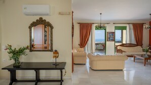 A spacious living room with a large mirror, a dining table, and two sofas. - Villa Panorama - With 60m Private Pool (Rethymno)