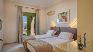 A hotel room with two beds, a glass table, a painting, and a view through a green door. - Villa Panorama - With 60m Private Pool (Rethymno)