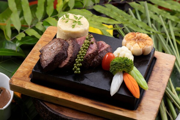 A wooden serving board with sliced beef, a round of cheese, a whole garlic bulb, and a variety of vegetables including broccoli and carrots. - Lomhae Kirirom Resort by EHM (Kampong Seila)