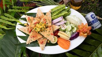 A plate of food with various vegetables and a beer can.