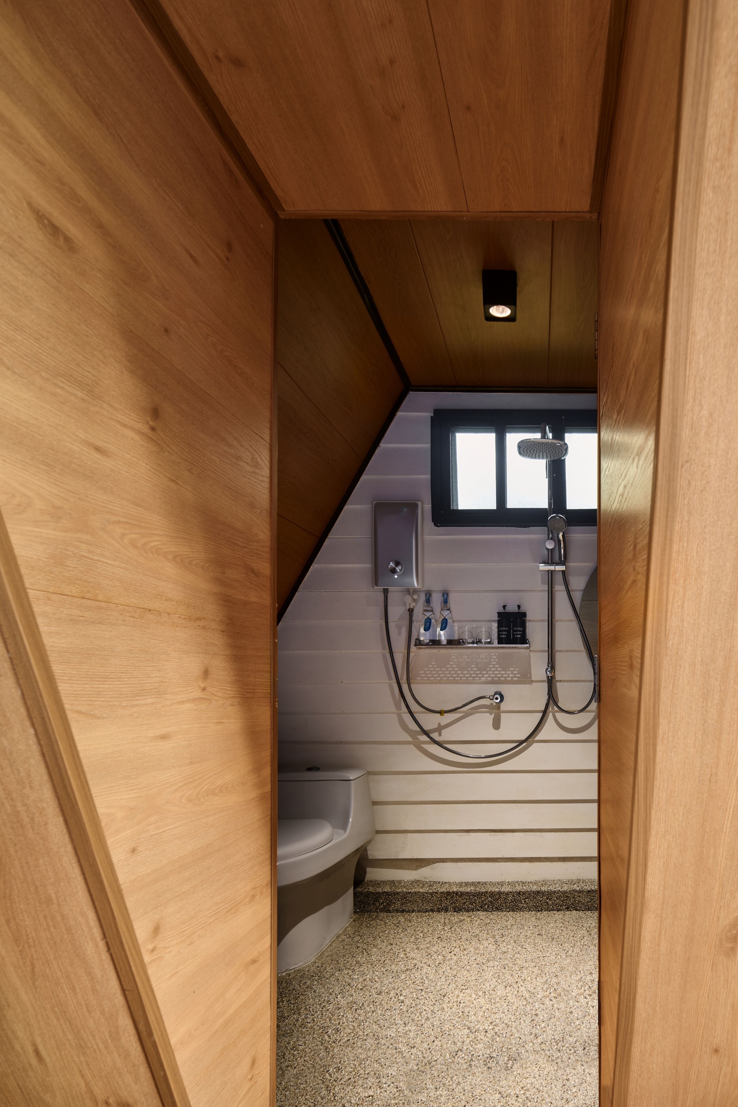 A compact bathroom with a shower, toilet, and sink.