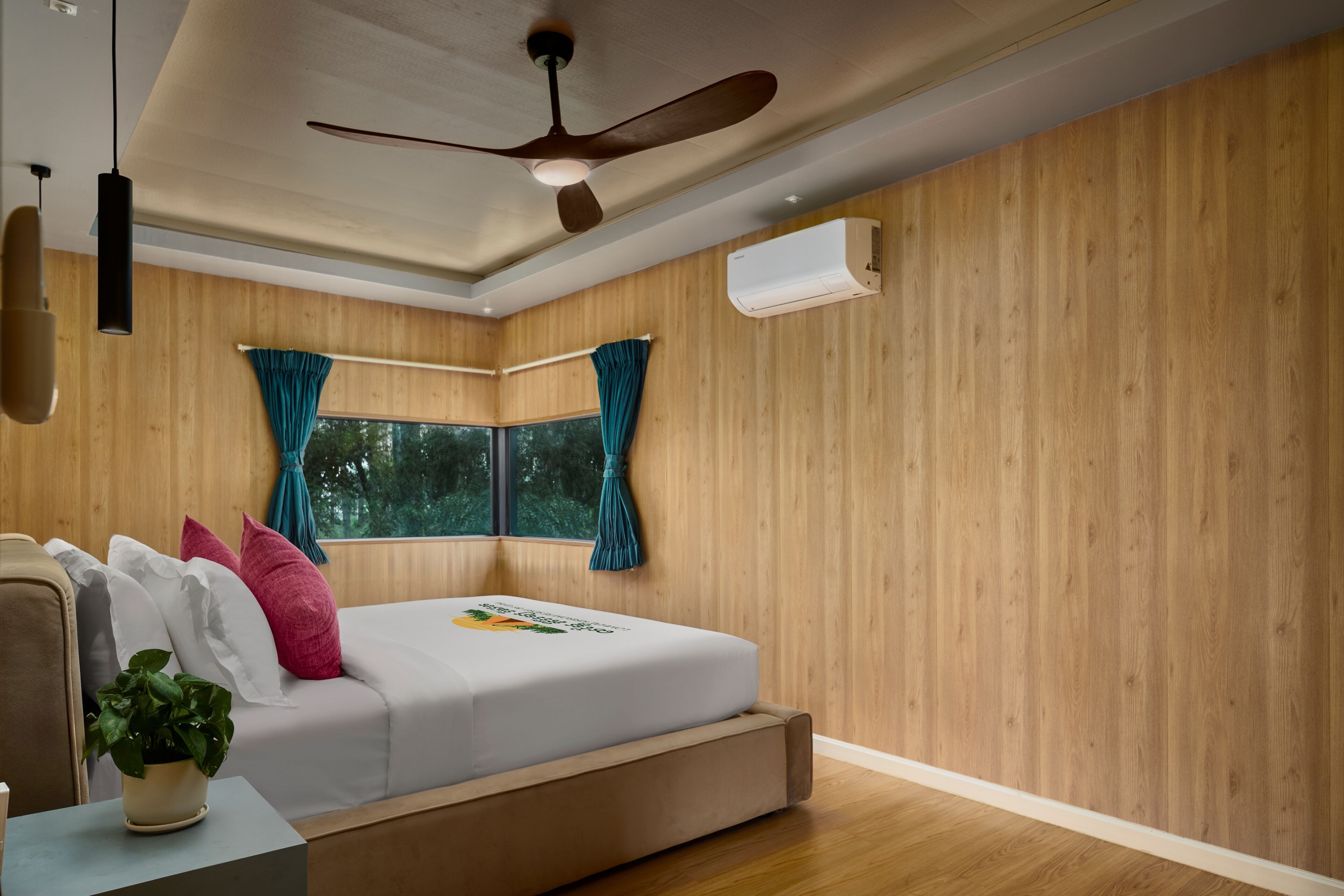 A bedroom with a bed, a ceiling fan, a window with curtains, and an air conditioning unit.
