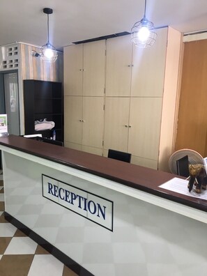 A reception area with a sign labeled "RECEPTION," a counter, and a large wardrobe with multiple doors. - Smart Place Pattaya (Pattaya)