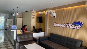 A reception area with a sofa, chairs, a table, and a reception desk. - Smart Place Pattaya (Pattaya)