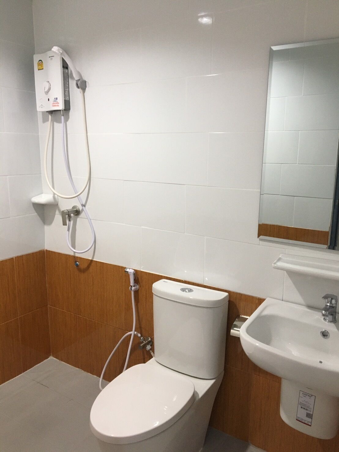 A bathroom with a toilet, a bidet, a sink, and a mirror.