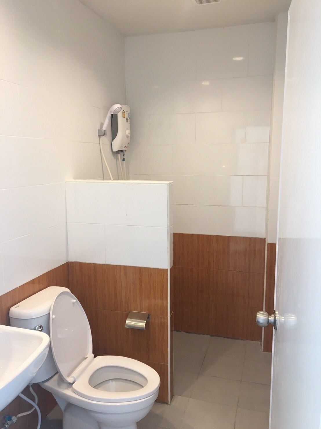 Ein modernes Badezimmer mit Toilette, Waschbecken und Handtrockner.