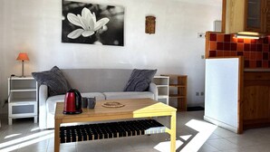 A modern living room with a sofa, coffee table, and a painting of a flower.