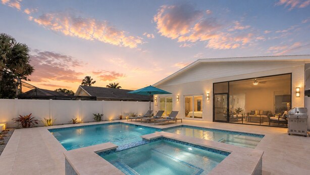 A modern outdoor pool area with two pools, lounge chairs, and a covered seating area. - New Listing Discount! Coconut Cove - Heated, Saltwater Pool/Spa - fully renovated! (Naples)