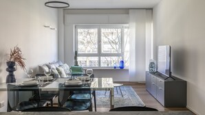 A modern dining area with a glass table, black chairs, and a sofa. - Le Barche66 Venice Apartments (Mestre)
