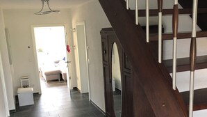A modern interior with a dark wood staircase, a large mirror, and a hallway leading to a living area. - Super nice and completely renovated vacation home between Szczecin Lagoon and Usedom (Ducherow)
