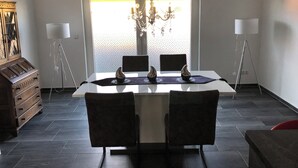 A dining area with a table, chairs, a chandelier, and a piano. - Super nice and completely renovated vacation home between Szczecin Lagoon and Usedom (Ducherow)