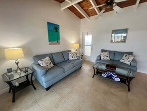 A living room with two sofas, a coffee table, and a lamp. - 05 Standard Plus - Screened Lanai (Siesta Key)
